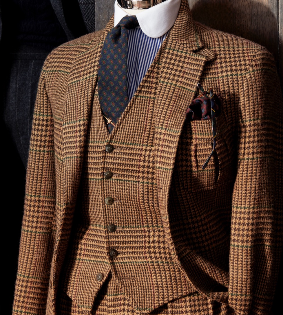 <strong>CHECKED OUT</strong><br/><span>A three-piece suit in a large-scale cognac-and-camel Glen check. The fabric was not only woven exclusively in Britain for the collection; it has a pattern detail that is purely Polo: a windowpane grid of wine and green “guard” the pattern, meaning the colours run along the edge of the plaid, giving it the unmistakable look of Ralph Lauren</span>